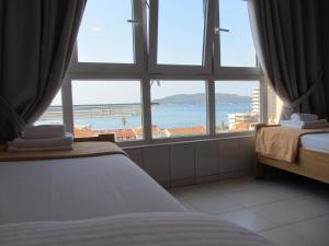 a bedroom with a large window with a view of the ocean at Cernogoriya voyage in Rafailovici