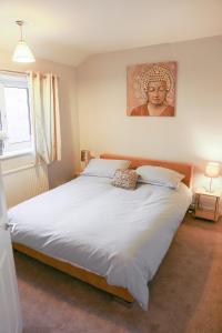 a bedroom with a large white bed with a picture on the wall at Zoo House Chester in Chester