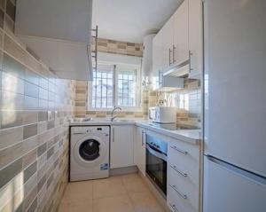 una cocina con lavadora y lavadora en Apartamento C.M., en Nerja