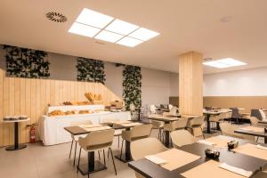 a restaurant with tables and chairs and a counter at Hotel Airiños 3* in Cangas de Morrazo