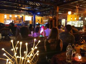 a group of people sitting at a bar at night at Ombak Dive Resort Perhentian Island in Perhentian Islands
