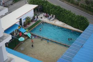 Draufsicht auf ein Schwimmbecken mit Menschen im Wasser in der Unterkunft Rinradee Place in Buriram