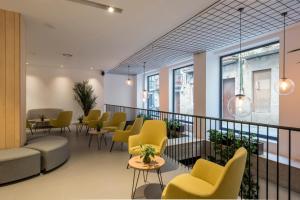 a waiting room with yellow chairs and tables at Hotel Airiños 3* in Cangas de Morrazo