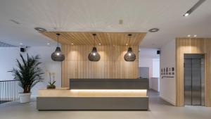 a lobby with a reception desk and pendant lights at Hotel Airiños 3* in Cangas de Morrazo