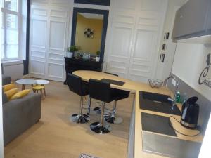 a kitchen and living room with a table and chairs at Coté Cour in Bergues