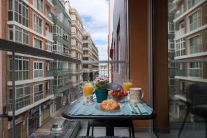 stół z jedzeniem i napojami na balkonie w obiekcie Sony Cosi Loft Canteras w mieście Las Palmas de Gran Canaria