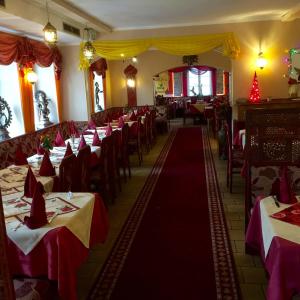 uma sala de jantar com mesas e cadeiras vermelhas e brancas em Jujhar's Gästehaus em Wasserburg am Inn