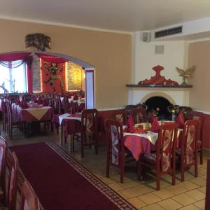 a dining room with tables and chairs and a fireplace at Jujhar's Gästehaus in Wasserburg am Inn