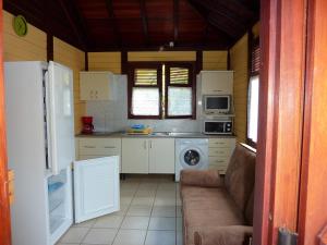 a small kitchen with a couch and a microwave at résidence la pointe marine in Deshaies