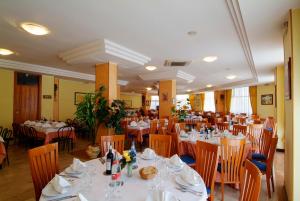 una sala da pranzo con tavoli e sedie bianchi di Residence Eurhotel a Montesilvano