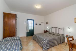 a bedroom with two beds and a table and a chair at Agriturismo Valle Martina in Saturnia