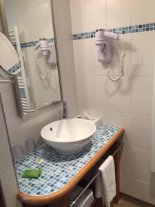 a bathroom with a sink and a mirror at Hôtel la Croix Blanche in Le Mont Saint Michel