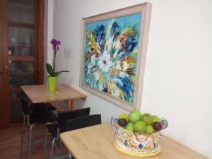 a painting of flowers and a bowl of fruit on a table at B&B Al Centro Storico in Agrigento