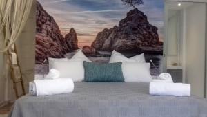 Un dormitorio con una cama con un cuadro en la pared. en Beach Hotel Kapahi, en Pefkari