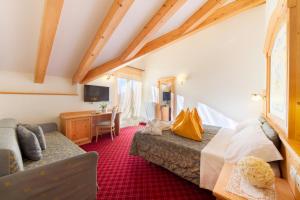 A bed or beds in a room at Alpotel Dolomiten