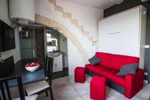 a living room with a red couch and a table at La Villa Tria Castella in Saint-Paul-Trois-Châteaux