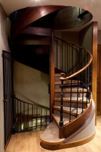a spiral staircase in a room with wooden floors at Hôtel la Croix Blanche in Le Mont Saint Michel
