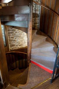 a spiral staircase in a room with wooden walls at Hôtel la Croix Blanche in Le Mont Saint Michel