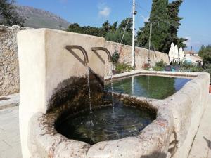a water fountain in the middle of a sidewalk at Piccola Baia in Scopello