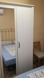 Puerta a un dormitorio con cama y silla en Piso en Malvarrosa, en Valencia