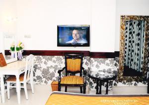 a living room with a tv on a wall at Hoang Thanh Thuy Hotel 2 in Ho Chi Minh City