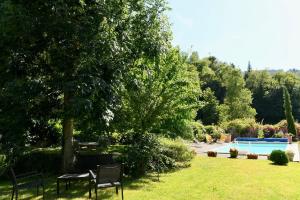 a yard with chairs and a tree and a swimming pool at La TULIPE SAUVAGE in Bourdeaux +9 photos