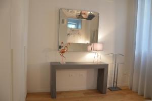 un escritorio con espejo y un flamenco rosa. en bright and silent apartment near two towers en Bolonia