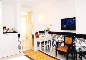 a kitchen with a table and a television on a wall at Hoang Thanh Thuy Hotel 2 in Ho Chi Minh City