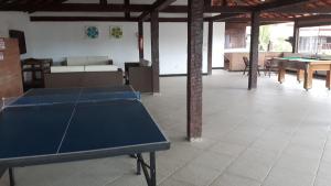 a ping pong table in a large room with tables at CONDOMINIO GERIBA APART HOTEL APTO 116 in Búzios
