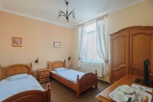 1 dormitorio con 2 camas, mesa y TV en Penzión Exclusive en Trenčín