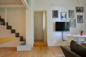 sala de estar con escalera y TV en la pared en bright and silent apartment near two towers en Bolonia