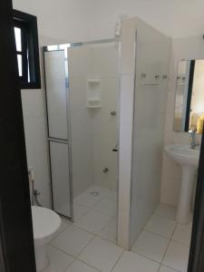 a bathroom with a shower and a toilet and a sink at Pousada Morada Das Toninhas in Ubatuba
