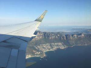 uma vista para a asa de um avião voando sobre montanhas em Camps Bay Villa em Cidade do Cabo