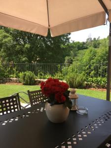 una mesa con un jarrón con rosas rojas. en Casa Rebellato, en San Zenone