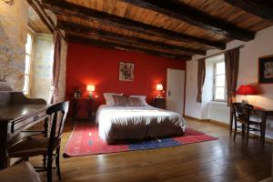 1 dormitorio con cama y pared roja en La Bruyle - Chambre d'hôtes de charme en Saint-Michel-de-Bannières