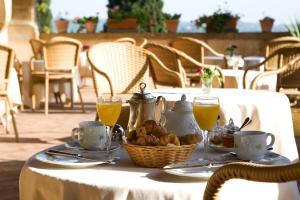 a table with a basket of food and glasses of orange juice at Casa Rosa in Florence