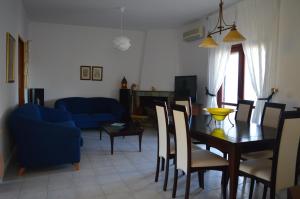 een eetkamer en een woonkamer met een tafel en stoelen bij United blue Resorts - White Sand in Karteros