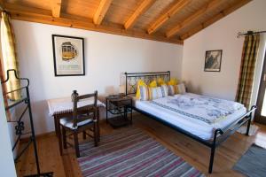a bedroom with a bed and a desk and a chair at Casa da Menina in Anceriz