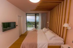1 dormitorio con 1 cama grande y TV en Villa Korina, en Primošten