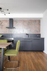 a kitchen with gray cabinets and a wooden table at Apartment Invalidovna with FREE parking in Prague