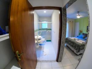 a bathroom with a mirror and a sink in a room at Pousada das Garças in Saquarema