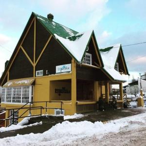 a building with snow on top of it at Hosteria Kupanaka in Ushuaia