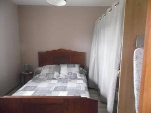 1 dormitorio con cama y cortina blanca en gîte " L'Albizia", en Prissac