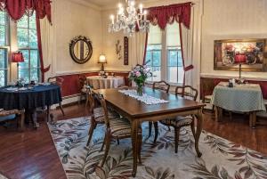 a dining room with a table and chairs and a chandelier at Silver Heart Inn & Cottages in Independence