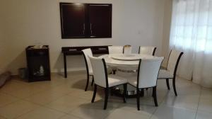 a dining room with a white table and chairs at Kandjo's Bed and Breakfast in Palatswe