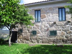 een stenen huis met een boom ervoor bij Casa dos Bisavós- Slow Down na rota do Românico in Porto