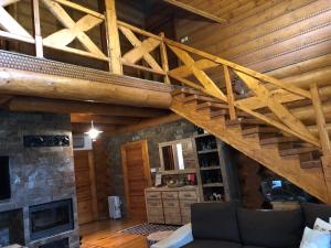 una sala de estar con chimenea y techos de madera. en Luxusný zrub en Lazisko