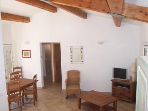 - un salon avec une table et une télévision dans l'établissement I Luminelli, à Porto-Vecchio