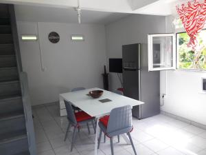 a kitchen with a table and chairs and a refrigerator at Duplex La Rivière in Deshaies