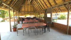eine Terrasse mit Tischen und Stühlen in einem Pavillon in der Unterkunft Pondoki Rest Camp in Groutfontein